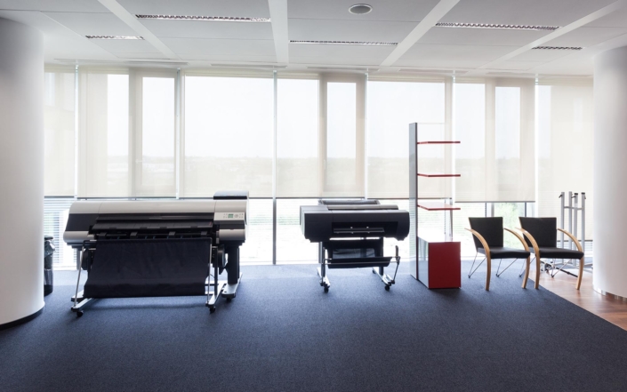 Side view of two large wide format printers in office Side view of two large wide format printers in office